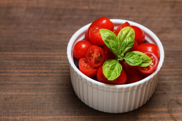 Bowl with tiny tomatoes decorated with basil leaves