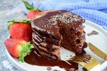 Double chocolate pancakes with fresh strawberries, chia seeds and chocolate sauce