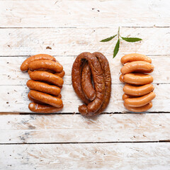 Composition of homemade, smoked cold cuts, sausages on light wooden boards, top view.