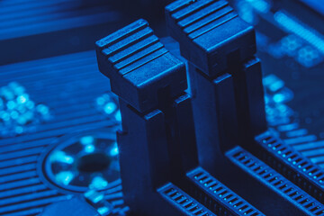 High tech dark background with elements of a computer motherboard in soft focus under high...