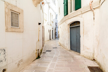 Italy, Apulia, Province of Taranto, Martina Franca. Narrow, curving street lined with white stucco...