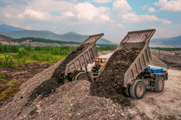A mining dump truck in an industrial mountainous area in the process. Mining © Letopisec