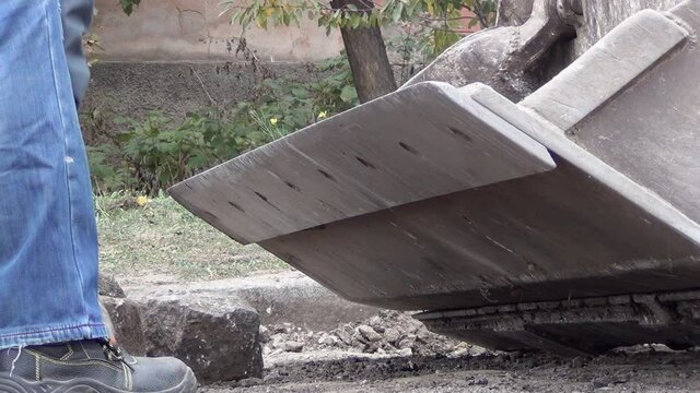 workers are loading granite stones from the road surface into the excavator bucket. High quality FullHD footage