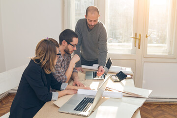 Three colleagues working from home on a project.