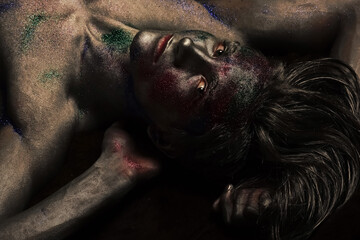 Fashion and art man concept. Guy on mysterious face with fashionable make up, covered with silver...