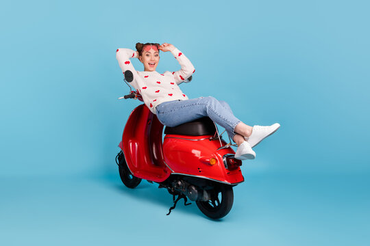 Full size photo of young happy cheerful girl in glasses enjoying free time on scooter isolated on blue color background