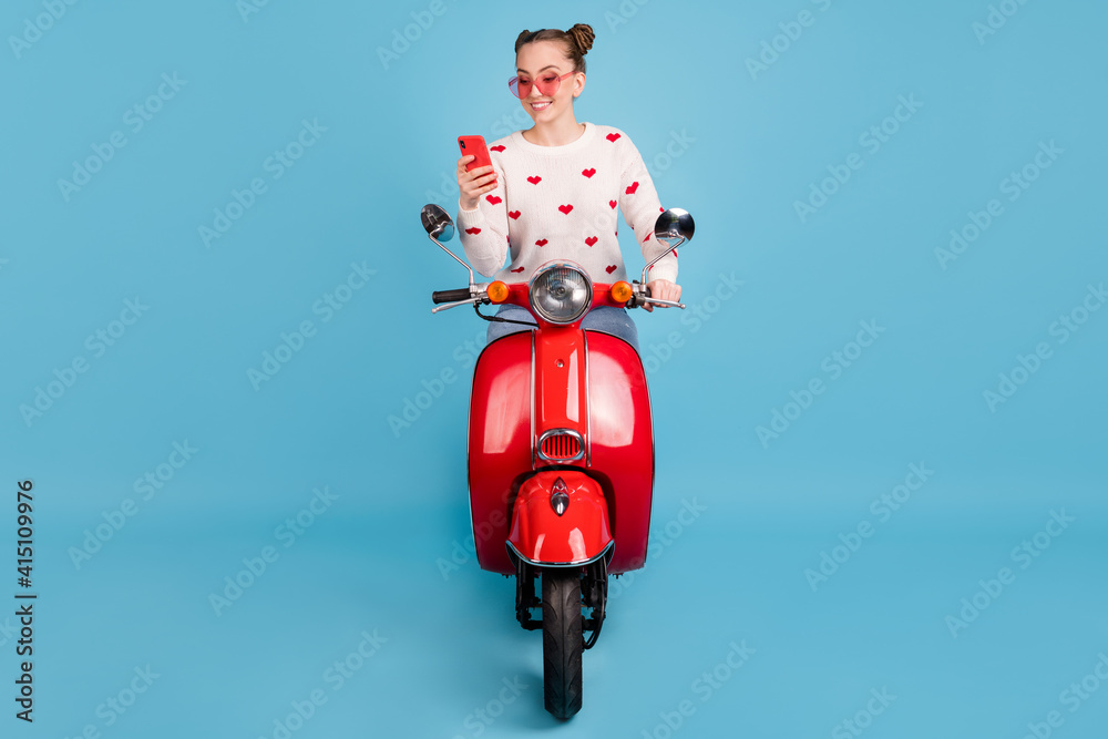 Poster full length photo of lady ride scooter hold phone wear sunglass heart print pullover isolated blue c