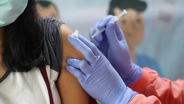 Close-up video of a woman's arm being injected with the corona virus vaccine