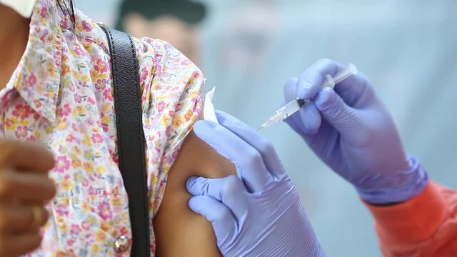 Close-up video of a woman's arm being injected with the corona virus vaccine