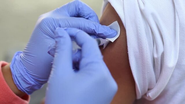 Close-up video of a man's arm being injected with the corona virus vaccine