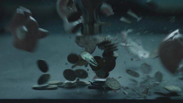Piggy Bank Hit, destroyed and smashes With Hammer Slow Motion. The coins from the piggy bank explode. The coin box is broken. The collapse of the financial system. World financial crisis