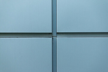 Cross-shaped metal cladding panels on the building wall