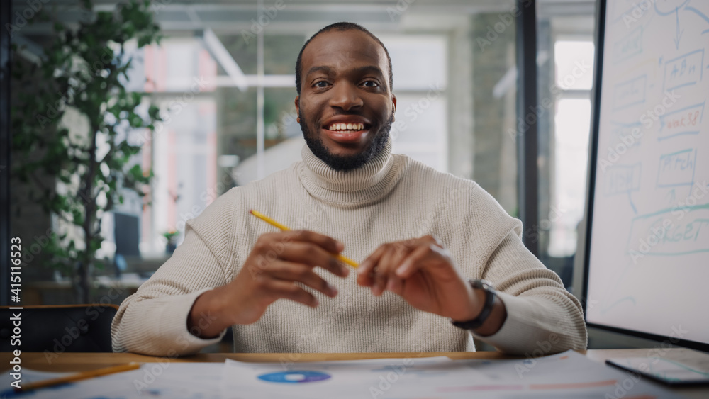 Aufkleber Point of View from Camera with Handsome Young Black Project Manager Making a Video Call in Creative Office Environment. Happy African American Male Specialist Talking to Colleague Over a Live Camera.