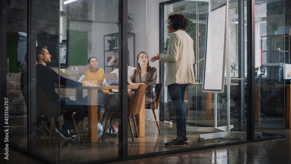 Poster Project Manager Makes a Presentation for a Young Diverse Creative Team in Meeting Room in an Agency. Colleagues Sit Behind Conference Table and Discuss Business Development, User Interface and Design.