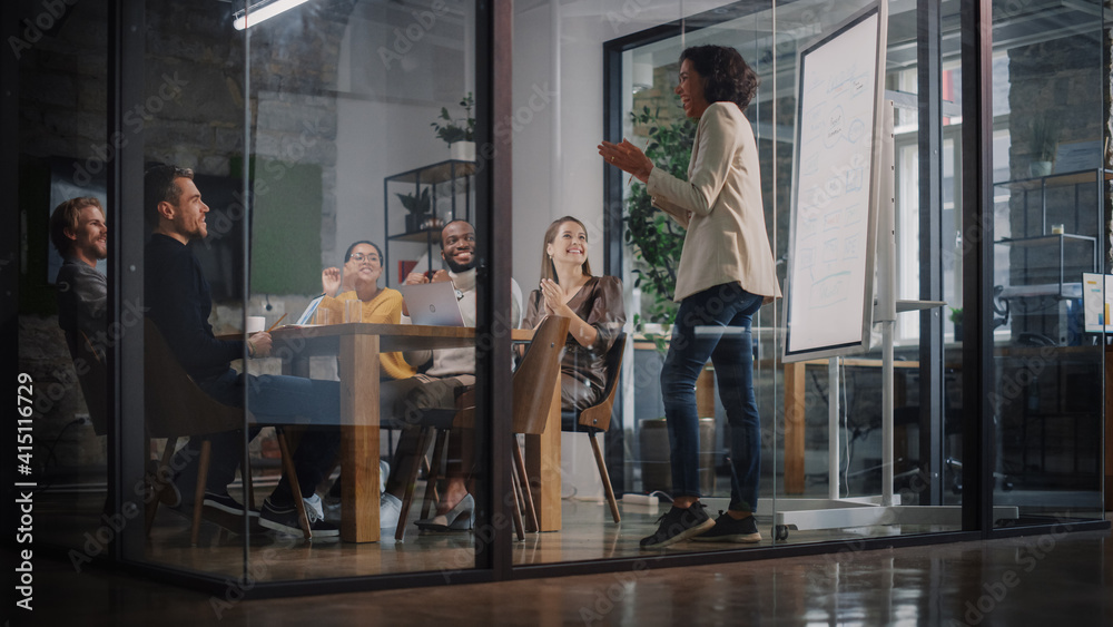 Poster Project Manager Makes a Presentation for a Young Diverse Creative Team in Meeting Room in an Agency. Colleagues Sit Behind Conference Table and Discuss Business Development, User Interface and Design.