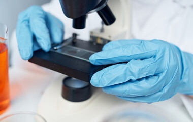 microorganism bacteria on glass doctor laboratory assistant in medical gloves