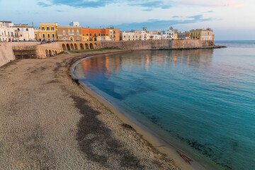 Italy, Apulia, Province of Lecce, Gallipoli. Beach and old town section over the Ionian Sea at...