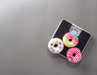 Donuts on the floor scales on gray background.