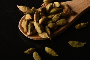 Green cardamom pods on black background