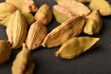 Green cardamom pods on black background