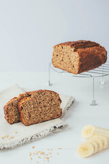 Two slice of freshly backed banana and oaten bread on gray napkin over wooden table. Healthy homemade breakfast. Copy space.
