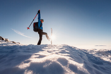 Mountaineer backcountry ski walking in the mountains. Ski touring in high alpine landscape. Adventure winter extreme sport. Sunny day