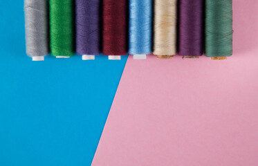 Colorful threads  isolated on pink and blue backgrounds.