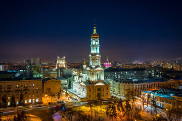 Aerial winter night view to Holy Dormition Cathedral - Uspenskiy sobor, with panorama of city in Kharkiv, Ukraine