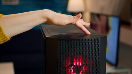 Woman gamer power on computer unit preparing for gaming tournament. Cyber performing on powerful personal computer in stylish room starting to play online shooter game © DC Studio