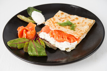 Traditional Russian thin pancakes with filling, red fish and cream cheese