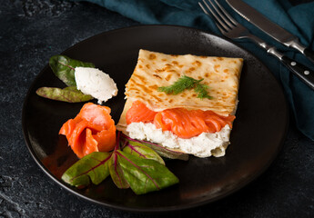 Traditional Russian thin pancakes with filling, red fish and cream cheese