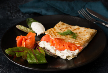 Traditional Russian thin pancakes with filling, red fish and cream cheese