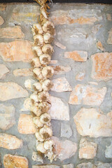 Traditional romanian garlic rope hanging on a stone wall in Charlotenburg, Romania