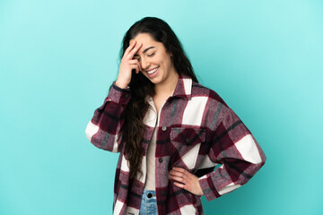 Young caucasian woman isolated on blue background laughing