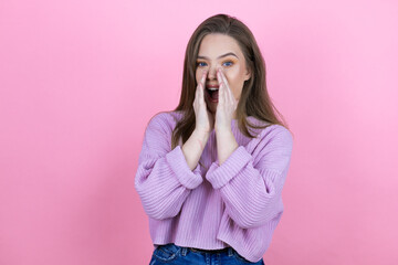 Young pretty woman with long hair standing over isolated pink background shouting and screaming loud to side with hands on mouth