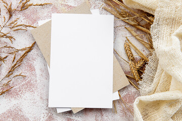 Stationery gentle natural background - a blank greeting card and flowers spikes. Top view, close-up, and copy space.