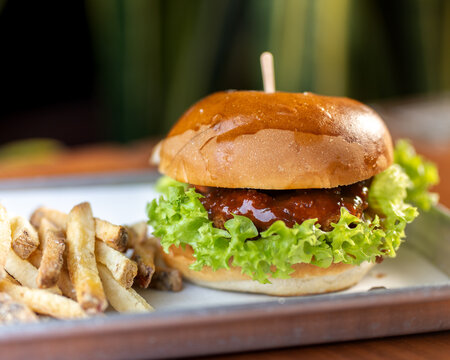 hamburguesas americanas con papas fritas en charolas de metal con mucho queso 
