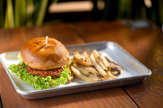 hamburguesas americanas con papas fritas en charolas de metal con mucho queso 
