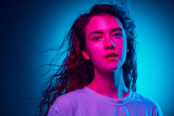 Fairy. Caucasian woman's portrait isolated on blue studio background in multicolored neon light. Beautiful female model. Concept of human emotions, facial expression, sales, ad, fashion. Copyspace.