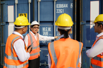 Asian foreman is explaining and teaching new training workers for various components of container to new inspection container worker.