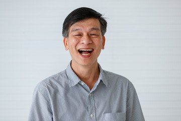 Portrait of warm personality senior older Asian man in casual dress friendly pose and laughing with happy and successful feeling and self-confident