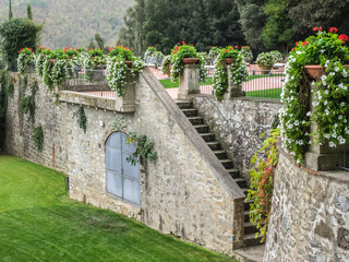 Europe, Italy, Chianti. Red geraniums and white petunias in pots surrounding the grounds of a villa.