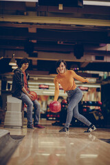 Fototapeta na wymiar Smiling Woman throws a bowling ball.