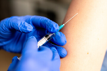 Close up photo of shot of vaccine to a patient's shoulder. Vaccination and prevention against flu or virus pandemic.