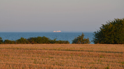 Obraz premium Ostseeküste in Kellenhusen mit Frachtschiff am Horizont 