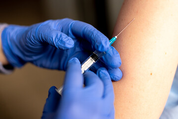 Close up photo of shot of vaccine to a patient's shoulder. Vaccination and prevention against flu or virus pandemic.