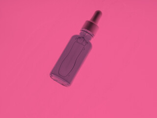 Hyaluronic acid serum generic bottle treatment on pink abstract background.