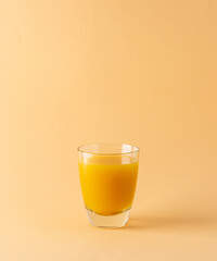 Delicious sweet orange or mango juice in glass isolated on beige background