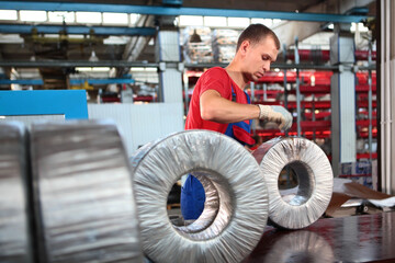 Fototapeta na wymiar The worker packs the finished bearings. Storage of finished products in a bearing manufacturing plant. The concept of hard physical labor.