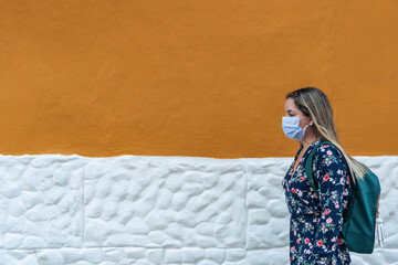 Young woman outdoors with medical mask. Pandemic woman with protective mask in the street. Concept of health and safety